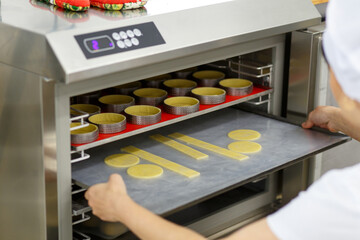 A uniformed cook puts pieces of cake in the refrigerator