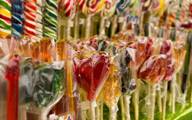 Multicolored sweet lollipops of different shapes of hearts and sticks
