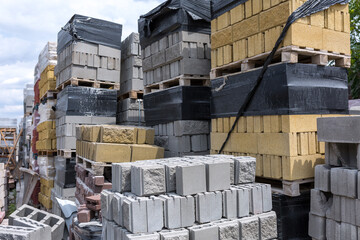 Industrial production of building cement pressed materials. High quality hollow concrete block or cement brick and paving stones. Finished products on pallets packed in film are waiting to be shipped.