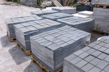 Industrial production of building materials from pressed cement mortar. High quality paving stones. Finished products on pallets packed in film are waiting to be shipped.