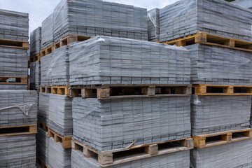 Industrial production of building materials from pressed cement mortar. High quality paving stones. Finished products on pallets packed in film are waiting to be shipped.