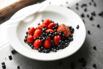 picture of juicy fresh ripe red strawberries in a white ceramic plate with light background