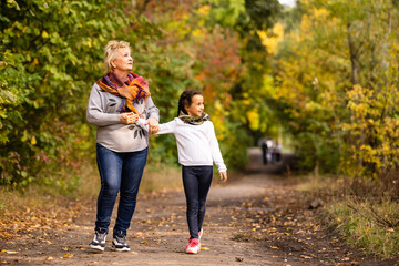 Portrait of grandmother and granddaughter in autumn park