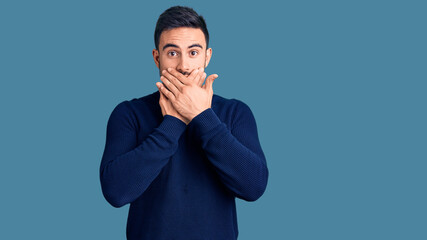 Young handsome man wearing casual clothes shocked covering mouth with hands for mistake. secret concept.