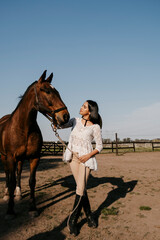 Latin woman touching a brown horse's head
