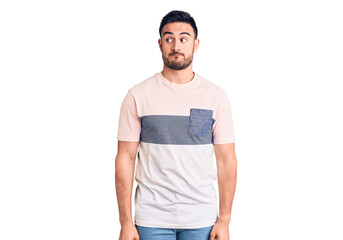 Fototapeta premium Young handsome man wearing casual clothes smiling looking to the side and staring away thinking.