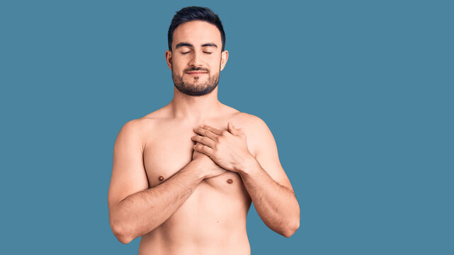 Young handsome man wearing swimwear smiling with hands on chest with closed eyes and grateful gesture on face. health concept.