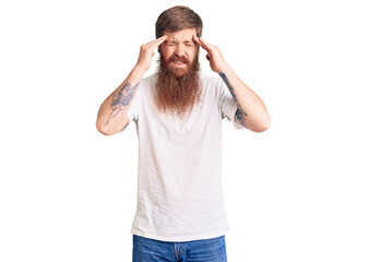 Fototapeta premium Handsome young red head man with long beard wearing casual white tshirt with hand on head for pain in head because stress. suffering migraine.