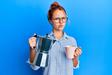 Young redhead woman drinking italian coffee skeptic and nervous, frowning upset because of problem. negative person.