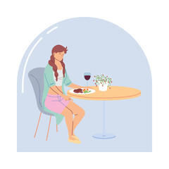 Young woman sitting in a restaurant having dinner with a glass of wine