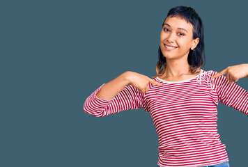 Young woman wearing casual clothes looking confident with smile on face, pointing oneself with...