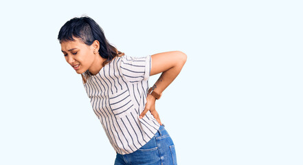 Young woman wearing casual clothes suffering of backache, touching back with hand, muscular pain