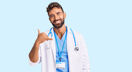 Young hispanic man wearing doctor uniform and stethoscope smiling doing phone gesture with hand and...