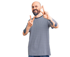 Naklejka premium Young handsome man wearing casual clothes smiling looking to the camera showing fingers doing victory sign. number two.
