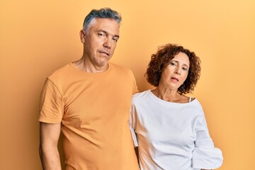 Beautiful middle age couple together wearing casual clothes looking sleepy and tired, exhausted for fatigue and hangover, lazy eyes in the morning.