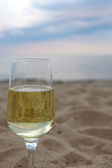 Glass of white wine on the seashore.
