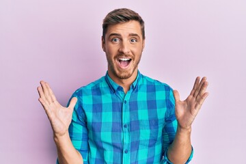 Handsome caucasian man wearing casual clothes celebrating victory with happy smile and winner expression with raised hands