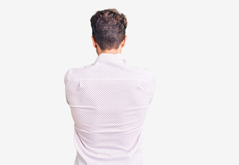 Young handsome man wearing business clothes and glasses standing backwards looking away with...