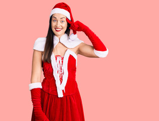 Young beautiful caucasian woman wearing santa claus costume smiling pointing to head with one finger, great idea or thought, good memory