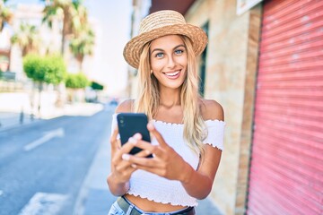 Young blonde tourist girl smiling happy using smartphone at the city.