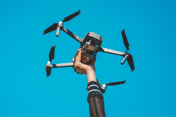 Woman hand holding DJI Mavic 2 Pro drone or quadcopter isolated on the blue sky background. 29.09.2020, Netherlands, Amsterdam