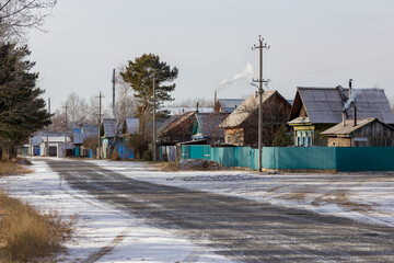 Street with wooden one-story houses in the Russian village