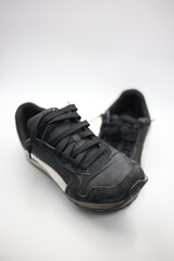 Sneakers negros rotos y sucios fondo negro, white