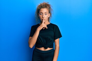 Fototapeta na wymiar Beautiful caucasian teenager girl wearing black sportswear asking to be quiet with finger on lips. silence and secret concept.