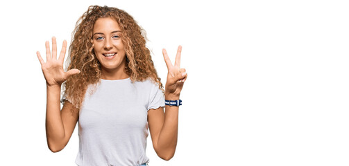 Naklejka na ściany i meble Beautiful caucasian teenager girl wearing casual white tshirt showing and pointing up with fingers number seven while smiling confident and happy.