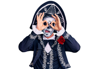 Young man wearing day of the dead costume over background doing ok gesture like binoculars sticking tongue out, eyes looking through fingers. crazy expression.
