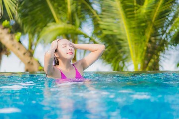 Portrait beautiful young asian woman smile relax around outdoor swimming pool in resort