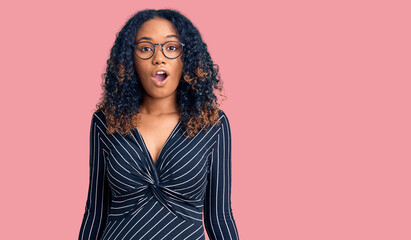 Young african american woman wearing casual clothes and glasses afraid and shocked with surprise expression, fear and excited face.