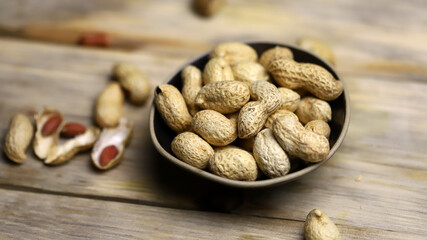 Peanuts in a peel in a bowl. Selective focus. Macro.