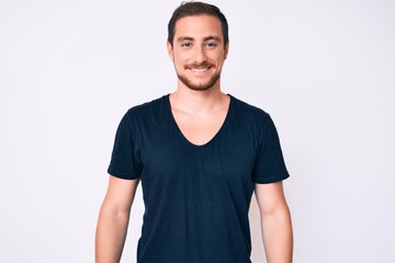 Young handsome man wearing casual clothes looking positive and happy standing and smiling with a confident smile showing teeth