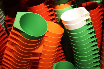Many flowerpots are stacked together, colorful, white, yellow, orange, green