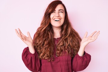 Young beautiful woman wearing casual winter sweater celebrating mad and crazy for success with arms...