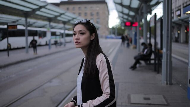 Young Asian woman waits for the tram in the city - urban photography