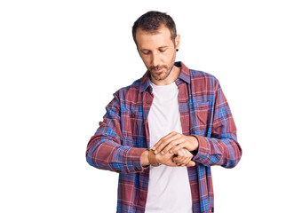 Young handsome man wearing casual clothes checking the time on wrist watch, relaxed and confident