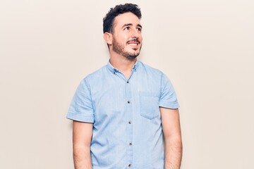 Fototapeta premium Young hispanic man wearing casual clothes looking to side, relax profile pose with natural face and confident smile.