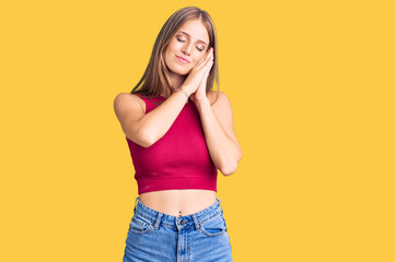 Fototapeta premium Young beautiful blonde woman wearing elegant summer shirt sleeping tired dreaming and posing with hands together while smiling with closed eyes.