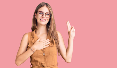 Young beautiful blonde woman wearing casual clothes and glasses smiling swearing with hand on chest...