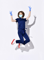 Young positive woman doctor dentist in dark blue uniform, gloves and protective medical mask...