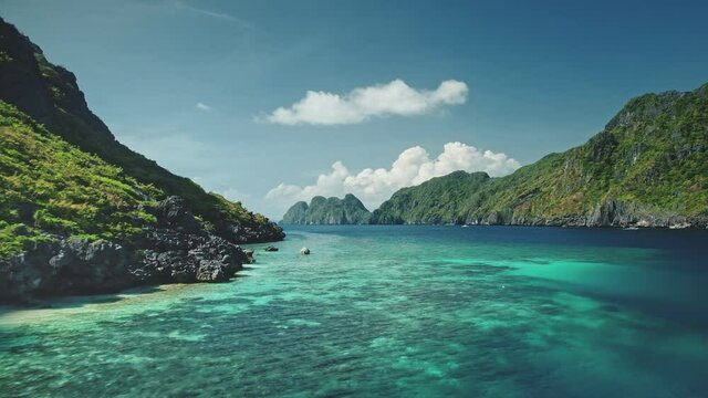 Blue sea bay at mountain islands of Visayas archipelago aerial view. Nobody nature seascape with deep blue water with turquoise shadows. Green tropic forest and plants at rock coast of El Nido Islets