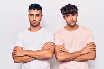 Young gay couple wearing casual clothes skeptic and nervous, disapproving expression on face with...