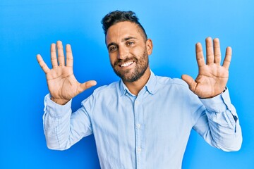 Fototapeta premium Handsome man with beard wearing casual clothes showing and pointing up with fingers number ten while smiling confident and happy.