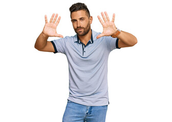 Handsome man with beard wearing casual clothes doing frame using hands palms and fingers, camera perspective