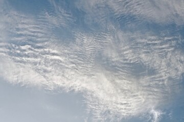 Blue sky with white small wavy clouds