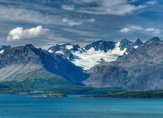 View To The Glacier Covered Lyngen Alps Mountains At Lyngenfjord On A Sunny Summer Day With A Clear Blue Sky And A Few Clouds