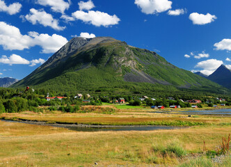 View To Olderdalen Town Surrounded By Mountains At Lyngenfjord On A Sunny Summer Day With A Clear Blue Sky And A Few Fluffy Clouds