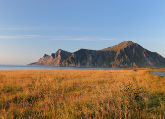 View To The Mountains Of Lofoten Island Flakstadoy In The Late Afternoon Sun On A Sunny Summer Day With A Clear Blue Sky And A Few Clouds